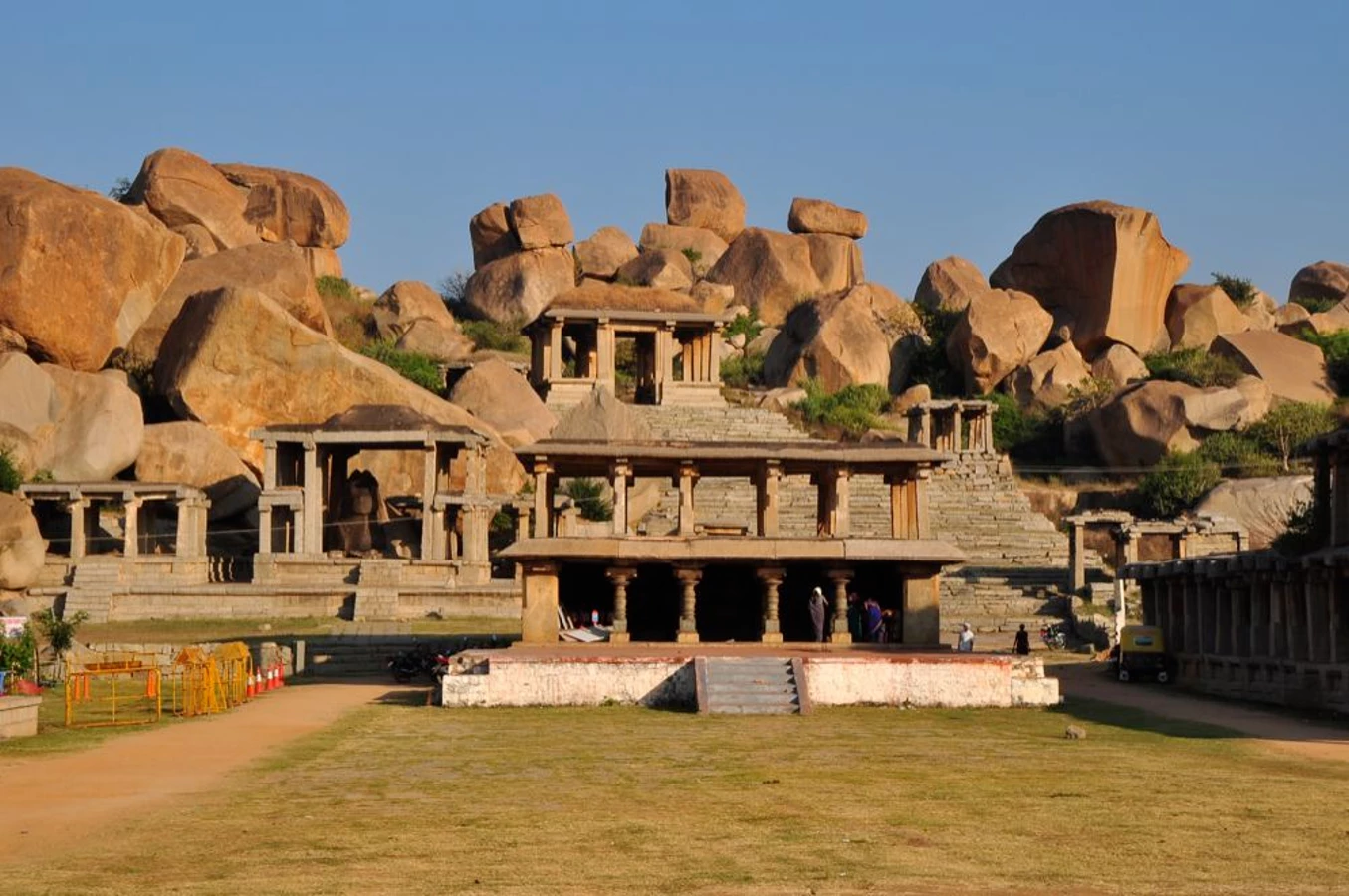 Step into the vibrant past with Christone Holidays at Hampi Bazaar, the once-bustling marketplace of the Vijayanagara Empire. This long, pillared corridor—flanked by ancient stone structures—was where 15th-century traders sold gems, spices, and exotic wares from across the world. The image captures the bazaar’s grandeur, with its symmetrical columns leading toward the majestic Virupaksha Temple gopuram in the distance. Today, local vendors still trade under the same historic arches, offering colorful handicrafts, traditional fabrics, and fresh coconut water. Christone’s expert guides bring the bazaar’s stories to life—pointing out original merchant quarters, hidden carvings of foreign traders, and the elevated pavilion where royalty once watched festival processions. As you walk these storied stones, imagine elephants carrying silk, the clink of gold coins, and the buzz of a cosmopolitan empire. Christone Holidays transforms this UNESCO site from ruins into a living history book.