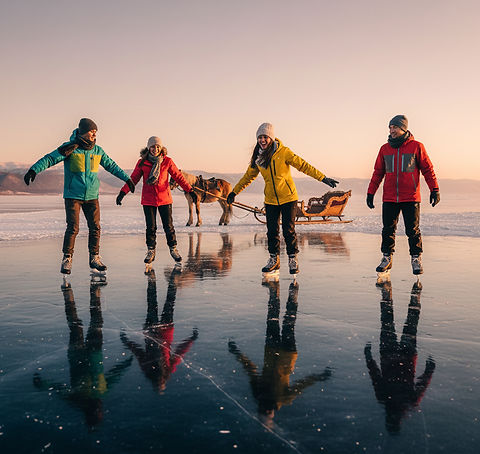 A group of friends ice skating and laughing on a perfectly smooth, reflective section of Lake Baikal's ice at golden hour, with a traditional horse-drawn sleigh in the background.