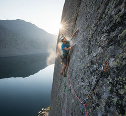 Sayan Mountains Climbing - Rock climber ascending "Zvezdny" route on Sleeping Sayan formation above