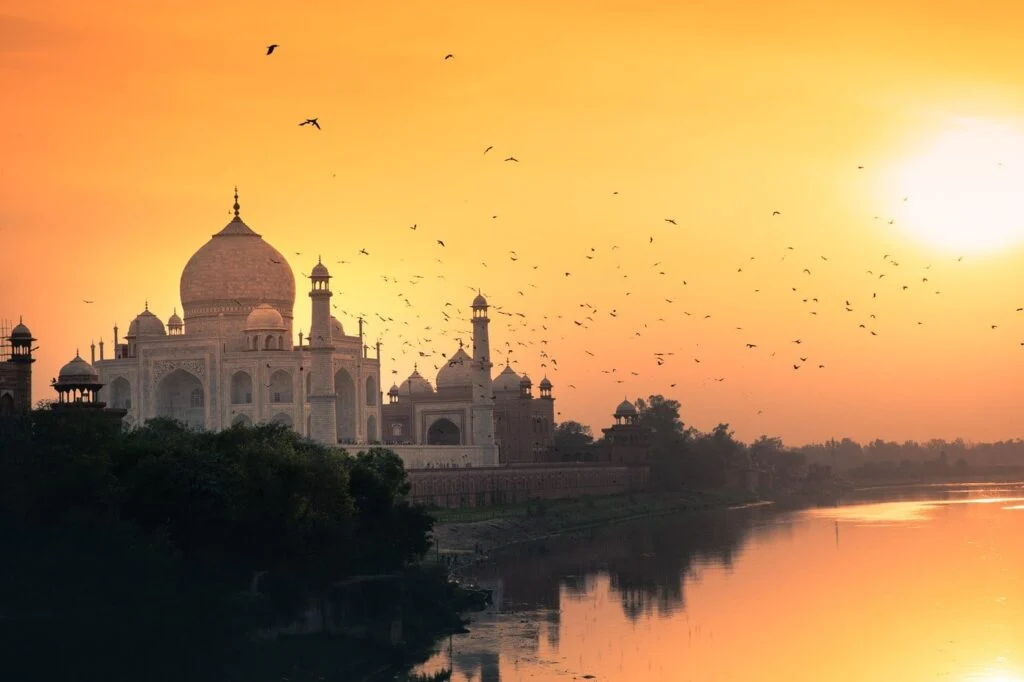 Taj Mahal at Sunset – A Golden Masterpiece with Christone Holidays : The iconic Taj Mahal bathed in warm golden hues during sunset, its pristine white marble glowing against the fading daylight. The Yamuna River reflects the monument's perfect symmetry, while Christone Holidays guests enjoy this magical moment from the famous Diana Bench viewpoint. Key Features Captured: The main mausoleum's changing colors from white to soft pink and gold Perfect reflection in the central pool leading to the monument Detailed pietra dura inlay work visible in the foreground The four minarets slightly tilting outward (earthquake-proof design) Christone Holidays' photography guide helping guests frame perfect shots Best Viewing Experience: Arrive 90 minutes before sunset for ideal lighting. Our tours include special access to less-crowded spots for uninterrupted views. Christone Holidays Insight: Learn how the setting sun reveals different architectural details each minute.