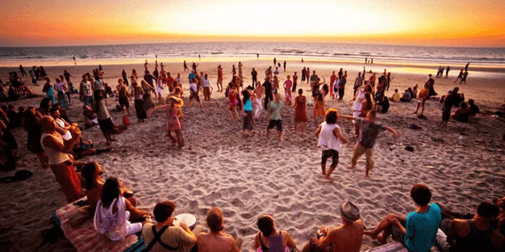 Goa beach party scene under the night sky with live music, beach bonfires, and colorful lighting creating a vibrant atmosphere. Tourists and locals gather along the sandy shores of Goa to enjoy upbeat DJ performances, electronic dance music, and tropical beats by the sea. The image captures people dancing barefoot on the beach, surrounded by tiki torches and palm trees swaying to the rhythm. Neon lights reflect on the waves of the Arabian Sea, adding to the energetic mood of this iconic Goan nightlife experience. Goa is famous for its beach parties that bring together global travelers in celebration of freedom, music, and coastal life. The crowd enjoys cocktails, beach games, and the sound of the ocean blending with the pulsating music. Hosted at popular spots like Calangute, Baga, or Anjuna Beach, these parties are a highlight of Goa tourism, especially for those booking with Christone Holidays – offering unforgettable nights of sea, sound, and celebration.Christone Holidays Goa