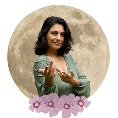 Smiling woman gestures towards camera with a full moon backdrop and flowers.