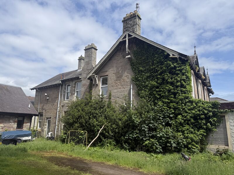 Overgrown stone property exterior before refurbishment