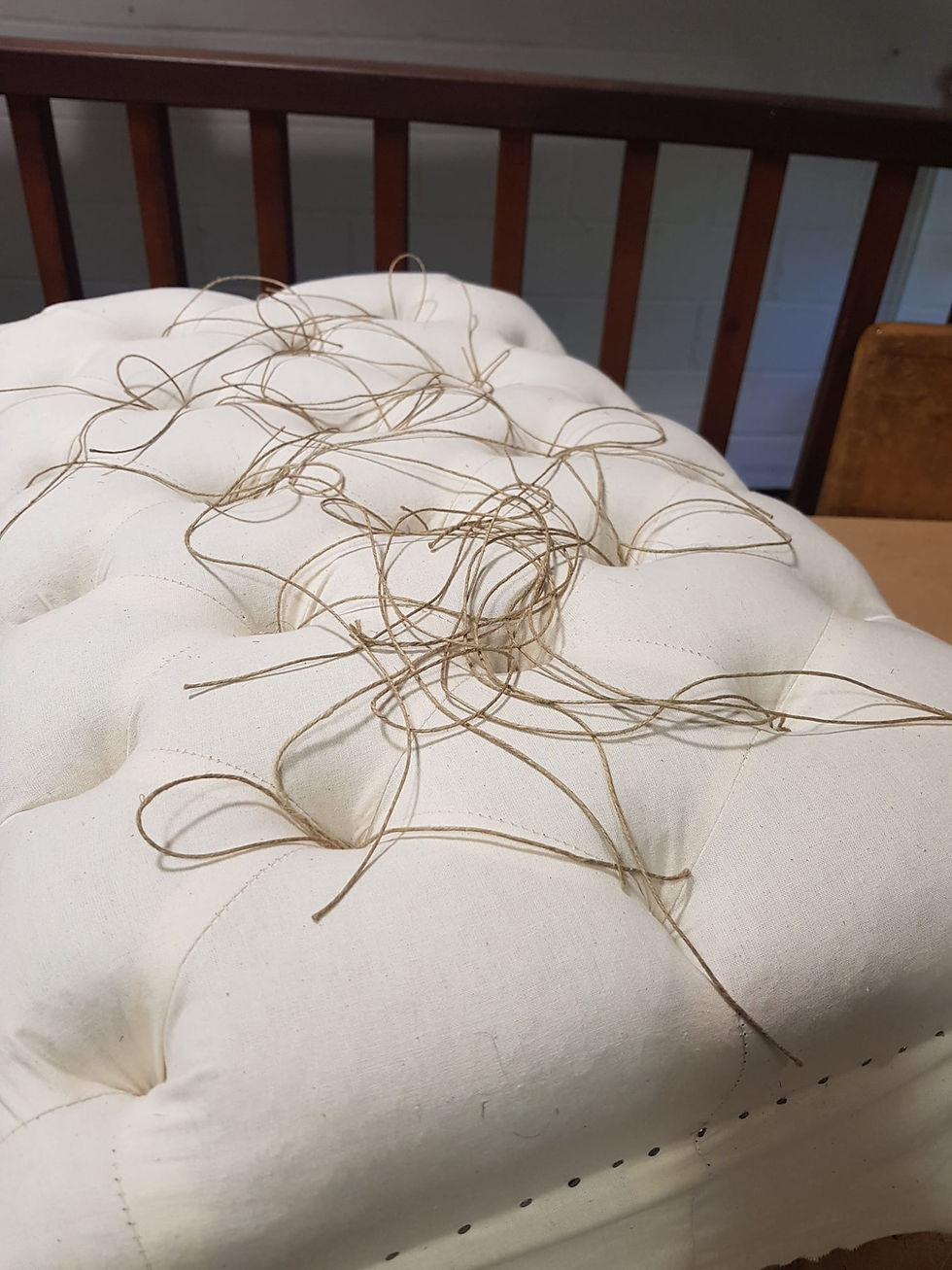 Image of a deep tufted stool in muslin