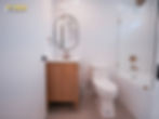 small bathroom in Los Angeles garage conversion ADU with tub shower combo, white oak vanity, and gold fixtures