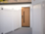 Los Angeles garage conversion ADU exterior with white stucco, wood front door, and black hardware details