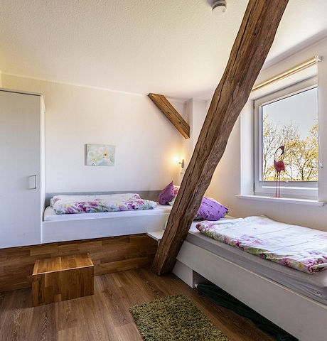 Gemütliches Zimmer mit zwei Betten und Blick ins Grüne