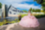 Quinceañera in pink dress at Denver Botanical Gardens posing near waterfall and lily pond in Colorado