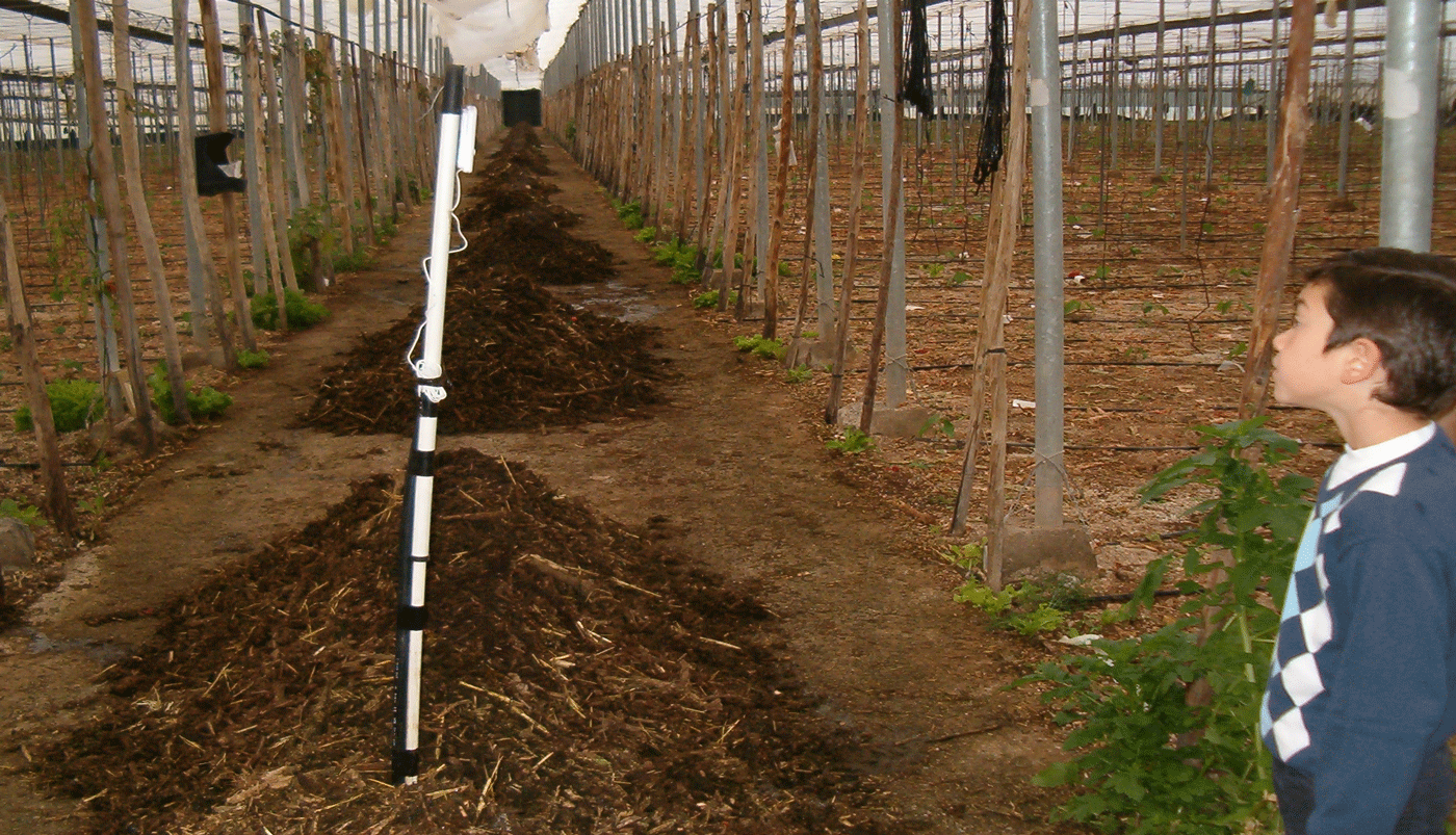 niño comprobando la temperatura del compost ecológico