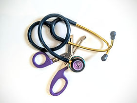 A stethoscope and a pair of emergency scissors on a white background