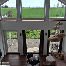 Blick von der Empore auf das Wohnzimmer und den Außenbereich