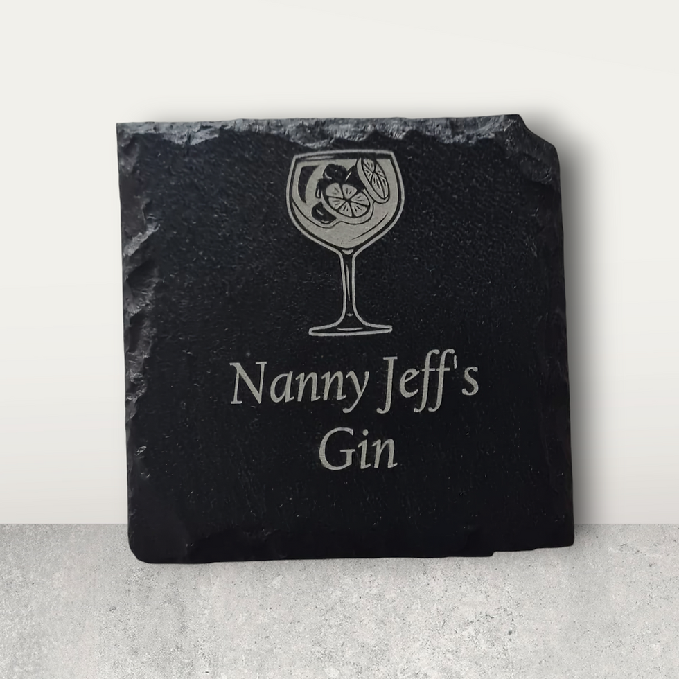 A square slate coaster showing a novelty design. These can be personalised with your own text on. This example says 'Nanny Jeff's Gin' with a picture of a glass of gin.