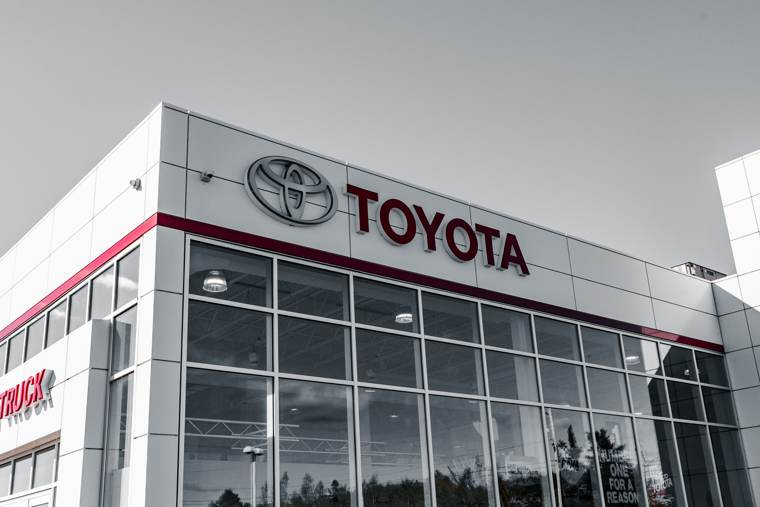 Toyota dealership facade with red signage and a large glass-fronted showroom