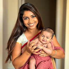 a woman holding a baby in her arms and a cute baby smiling with one dimple in her hands. m