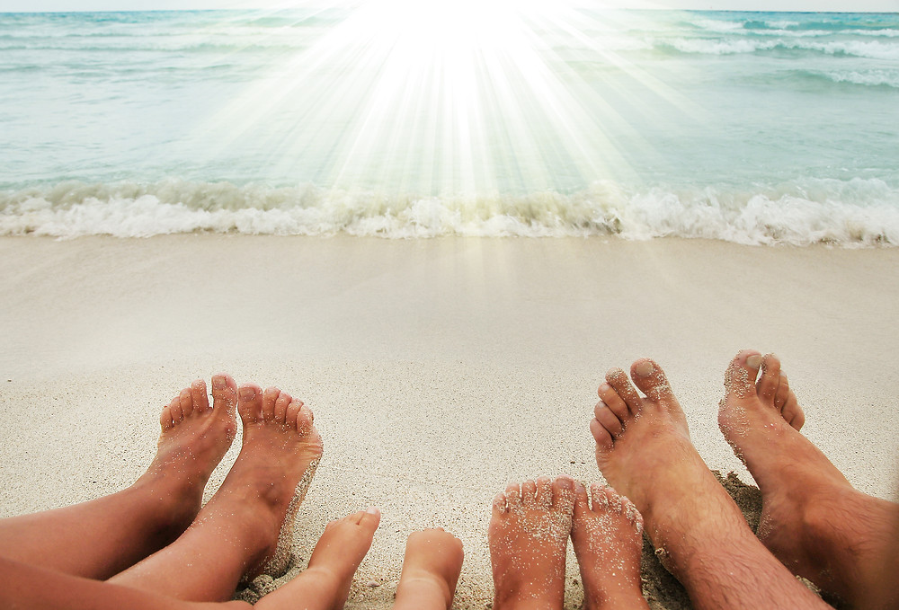 A family of four lay on the beach with bare feet after using oregano oil for toenail fungus