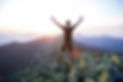 caucasian-man-hiker-is-on-the-peak-of-green-stones-mountain-watching-sunset-with-hands-in-