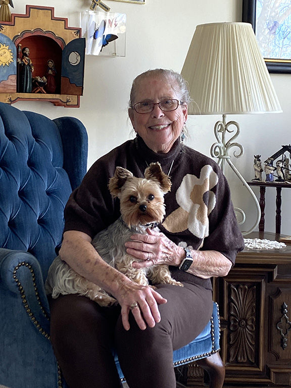 Cathy Johnson and her dog Chewy are surrounded by nativity sets throughout the room. Photo by Julie Parent