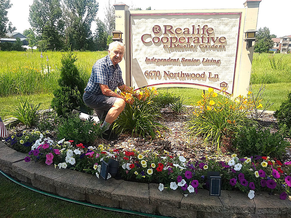 Resident Roger Dohrmann takes care of the flowers around the entrance.