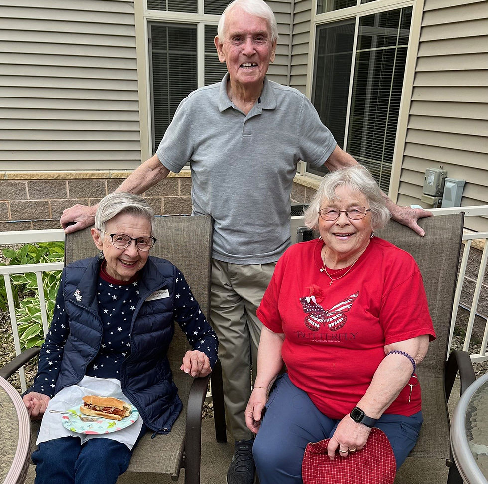 Mary Lee Kragenbring, Roy Evans, and Amy Schaefer attend a Fourth of July BBQ celebration at Realife Cooperative at Mueller Gardens.