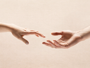 Duas mãos a aproximarem-se sem se tocarem, simbolizando ligação emocional e distância nas relações.