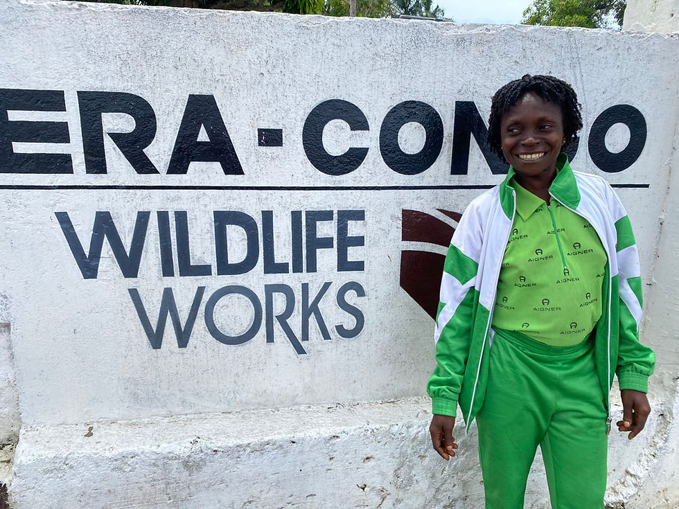 Woman in all green in front of a Wildlife Works sign