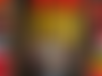 Three people holding world flags stand under gold "50" balloons. Red, black, and white balloon arch in background. Celebratory mood.