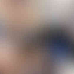 People conversing around a table with pastries and coffee cups. Colorful paper decor hangs above, with art on the walls, creating a friendly mood.