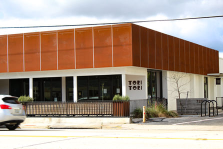 Exterior of Tori Tori restaurant with modern orange facade