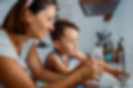 Child and mother drinking water from reverse osmosis system under sink