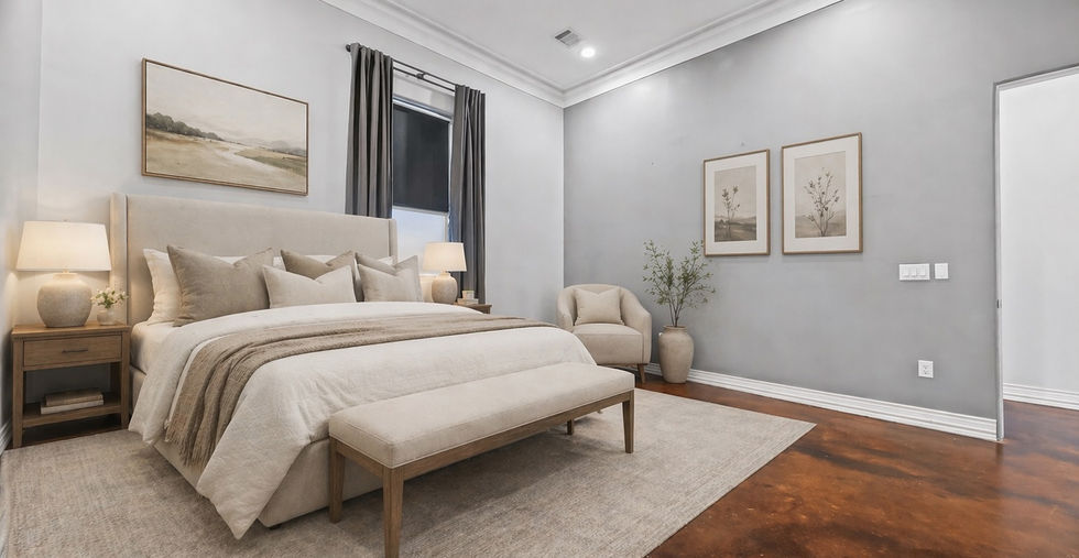 Staged primary bedroom in Unit 202 at 5801 Winsome Lane Houston TX 77057 with king size bed gray walls stained concrete floors crown molding and natural light