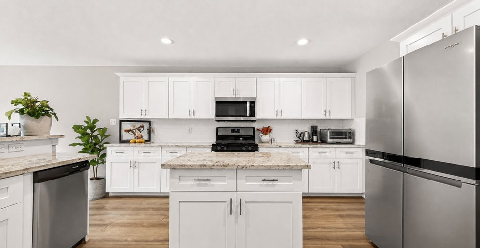 Updated kitchen with granite island, white shaker cabinets, and stainless refrigerator at 835 Stevens Creek Lane in a gated Richmond TX community.