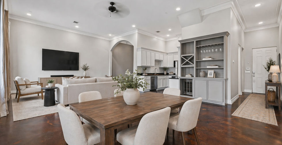 Open concept living dining and kitchen area of Unit 202 at 5801 Winsome Lane Houston TX 77057 showing white cabinetry custom built-in shelving hardwood floors and high ceilings