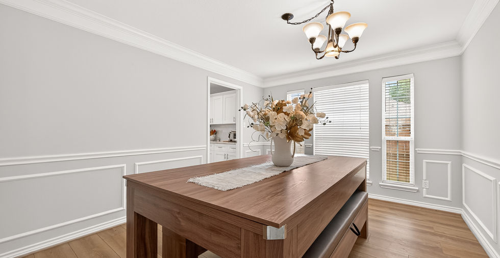 Formal dining room with wainscoting wall detail and chandelier inside a 4-bedroom home at 835 Stevens Creek Lane in Richmond TX 77469.