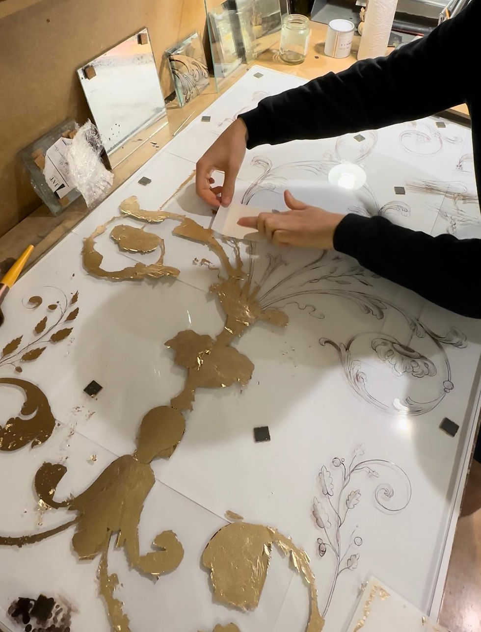 applying moon gold leaf on a reverse side of the glass