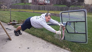 John Schott hanging on a basketball goal after cutting it down.