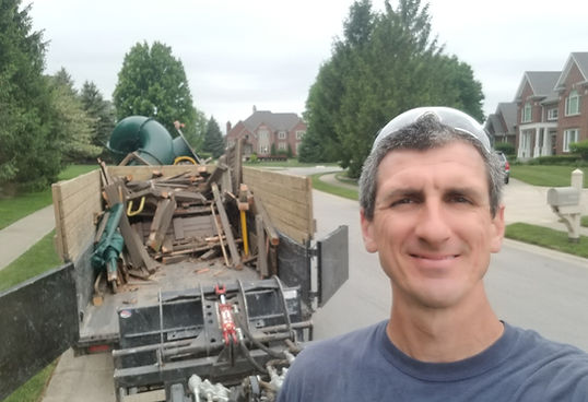 John Schott with a fully demolished wooden playset loaded into a Schott Services dump trailer in Indianapolis; click for a swing set removal estimate.