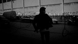 Actor running in the middle of the street in a medium-wide shot in a techno music video by SNTS produced and directed by Acid Thermal