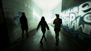 Wide shot of 3 subjects in silhouette walking through the streets of Barcelona in a scene from the music video “Contemporary Practices” directed by Acid Thermal for Edgar de Ramon.