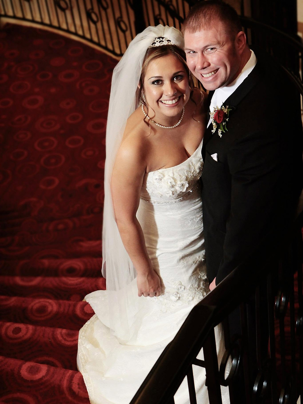 Wedding portrait of a couple on a red staircase, vertical image