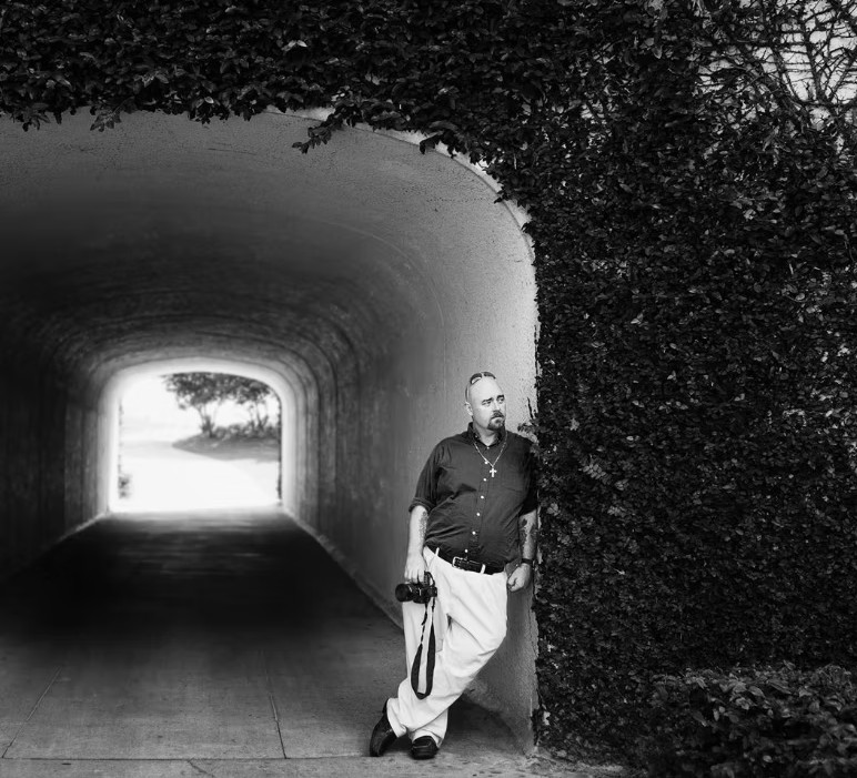 Wedding photographer holding a camera under an archway