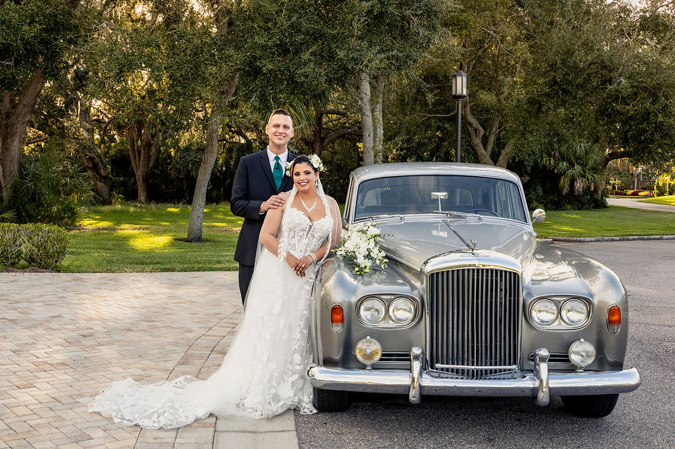 Bride and groom posing with a vintage car outside Harborside Chapel in Safety Harbor Florida during their wedding day