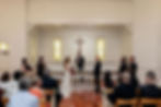 Bride and groom exchange vows at a church altar.