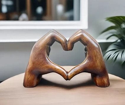Creative heart resin statue of two hands forming a heart.