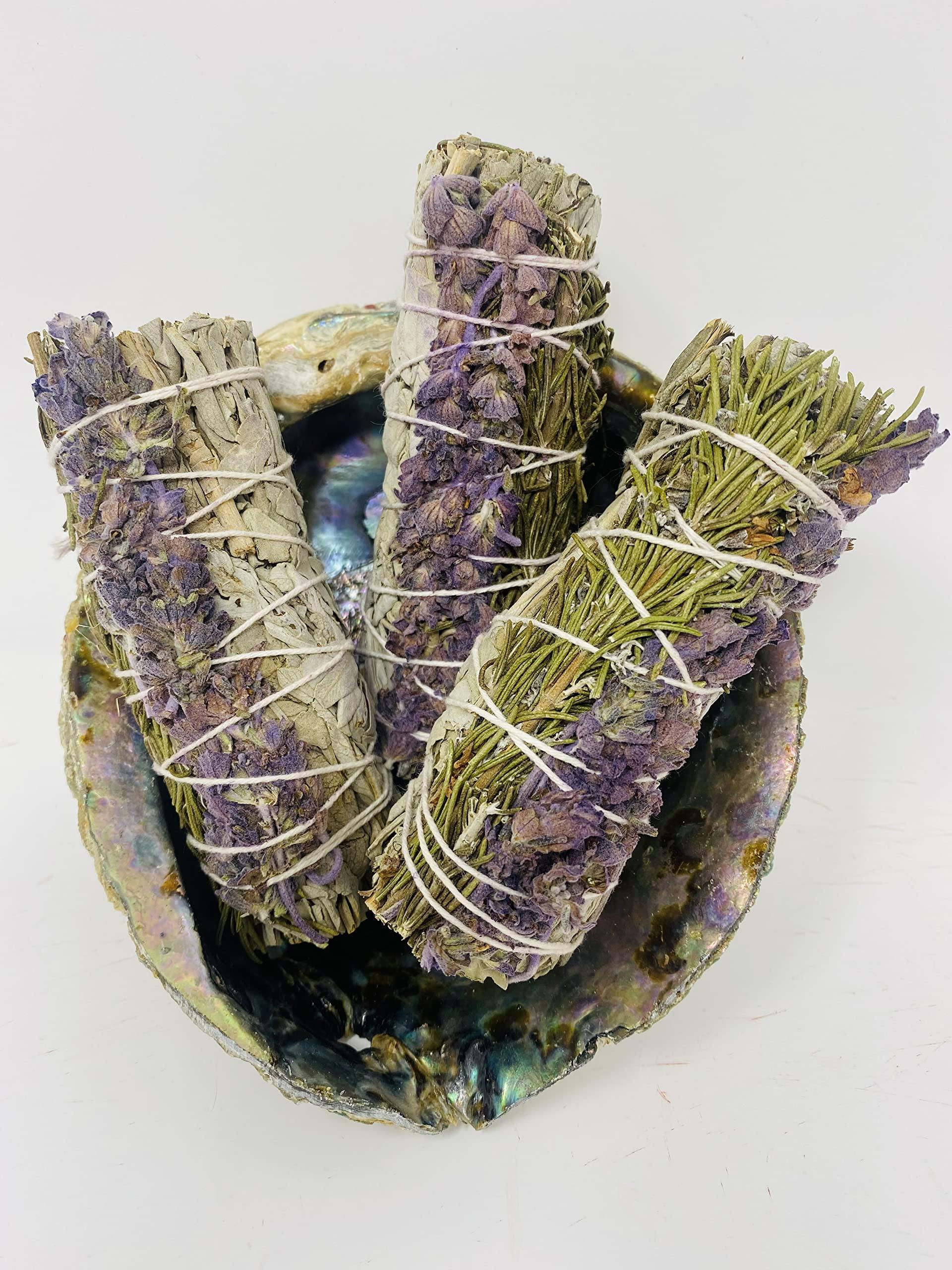Three lavender sage smudge sticks in an abalone shell
