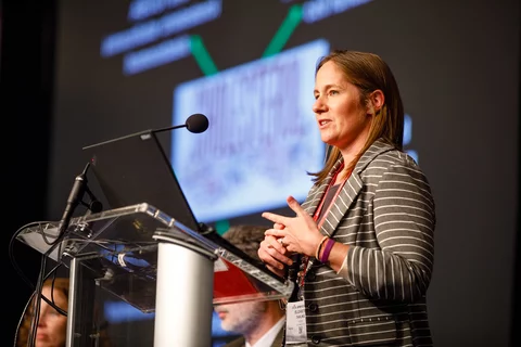 Liz speaking at podium.