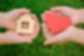 in children's hands a small heart and a model of a house. View from above. The concept is