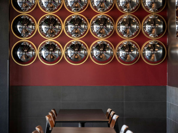 focal point wall with 3d mirror design chandelier lighting large tv for sports tile wainscoting in restaurant design large window with daylighting covered patio red stripe on wall 