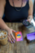 Tarot desk with the two of cups with vibrant graphic design on a table with coffee