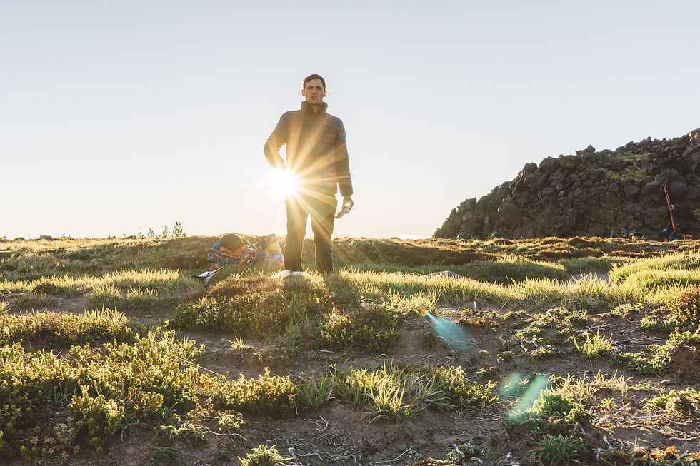 A man stands in the outdoors poised to champion small business. The sun glistens behind him as it catches the lens and flares just so.