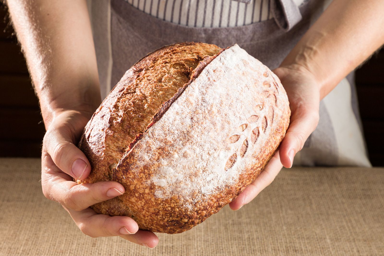 Mains tenant une miche de pain